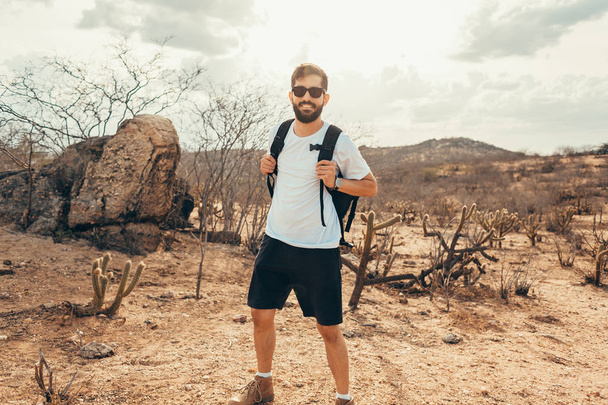 Man traveling with backpack hiking in desert. Travel lifestyle success concept - Fotografie, Obrázek