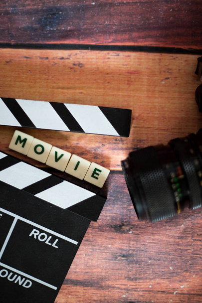 Filmové klapky a starý fotoaparát na dřevěné pozadí, střílet film - Fotografie, Obrázek