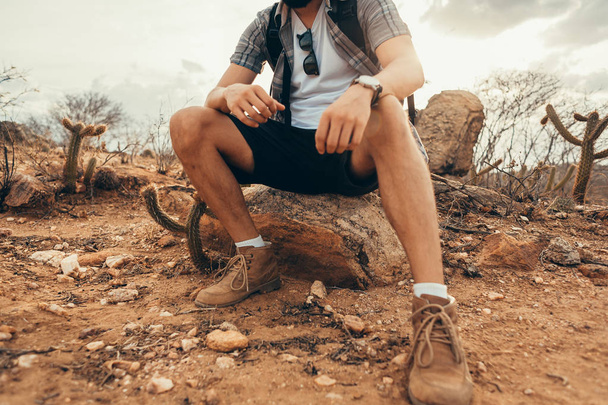 Young man relaxing and enjoying the ambience after long hike in the desert - Photo, Image