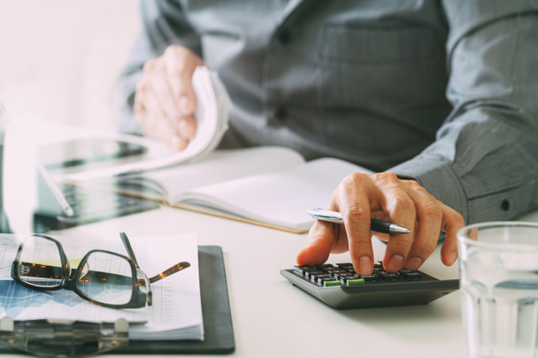 бизнесмен ручной работы с финансами о стоимости и калькулятор
 - Фото, изображение