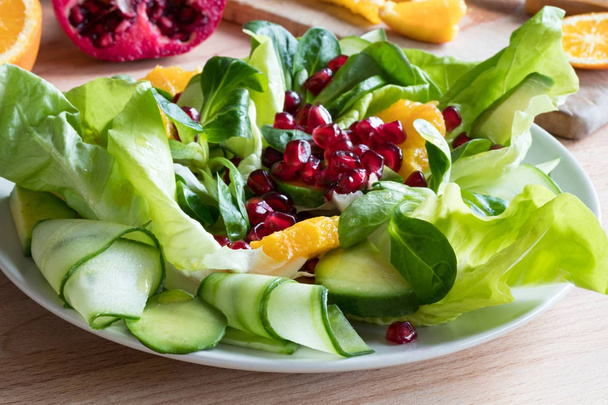 Vegetable salad - lettuce, corn salad, cucumber, avocado, orange - Photo, Image
