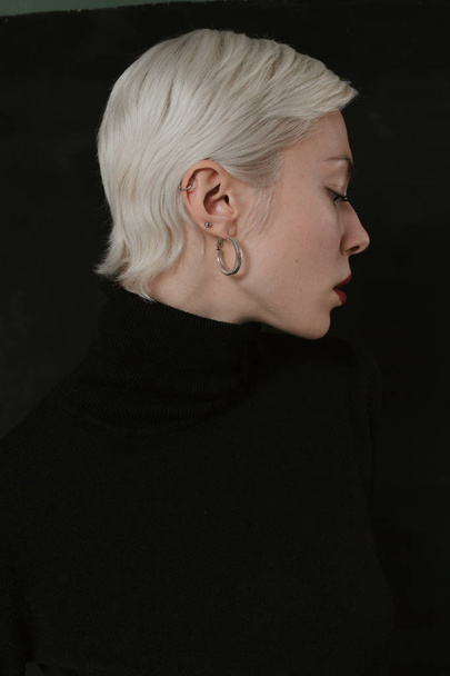 Όμορφη συναισθηματική κοπέλα με άσπρα μαλλιά σε μαύρο φόντο - Φωτογραφία, εικόνα