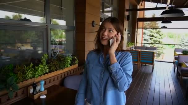 junges Mädchen spricht in Restaurant in Zeitlupe mit Smartphone. - Filmmaterial, Video