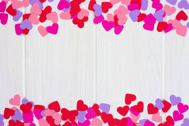 Dubbele rand van kleurrijke Valentijnsdag papier hart tegen een witte achtergrond van hout - Foto, afbeelding