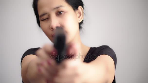 genç kadın Asyalı kız silahla seçici odak amaçlayan bir silah tutan - Video, Çekim