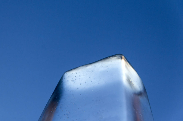 O topo do bloco de gelo na forma de um trapézio contra o fundo do céu azul. Close-up. O conceito de aquecimento global ou permafrost
. - Foto, Imagem