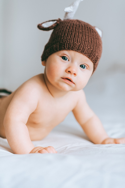 portrait en gros plan de l'enfant en bas âge en bonnet de cerf tricoté au lit
 - Photo, image