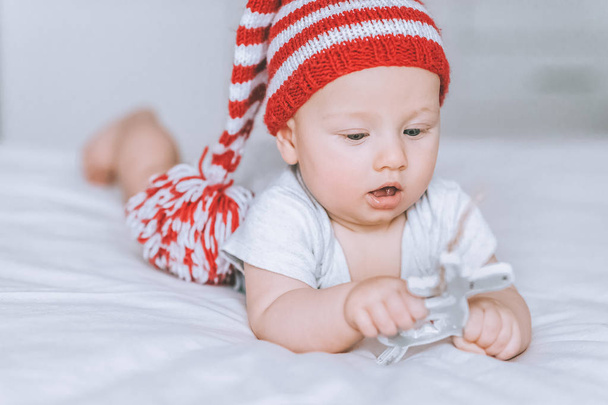 bambino neonato eccitato che gioca con la decorazione dei cervi giocattolo a letto
 - Foto, immagini