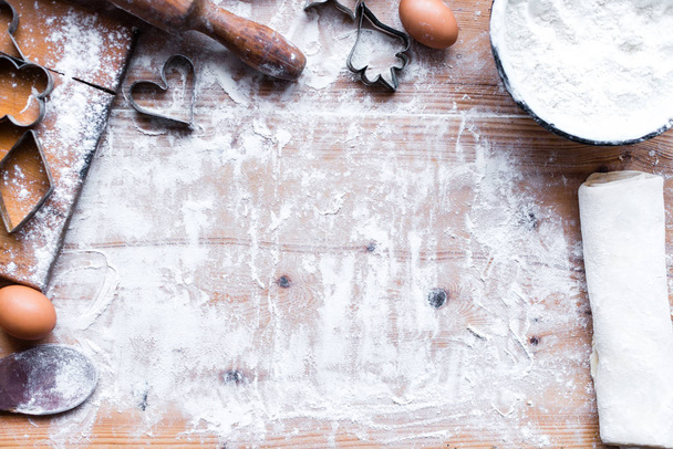 massa de farinha fresca feita com formas de biscoitos na mesa de madeira
  - Foto, Imagem