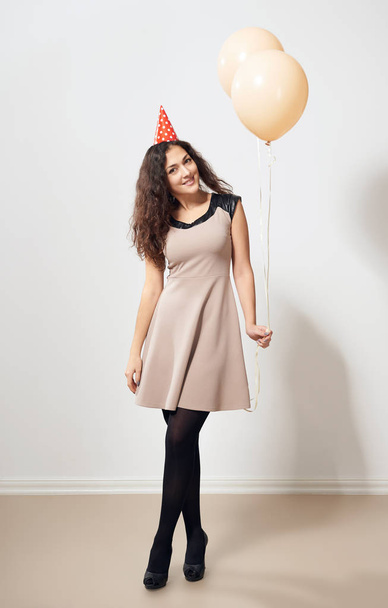 Szczęśliwa młoda kobieta lub dziewczyna w brązowy sukienka z powietrza balony helowe, koncepcja wakacje - Zdjęcie, obraz