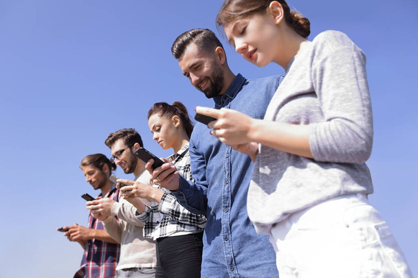 young people using smartphones to search network - Foto, imagen