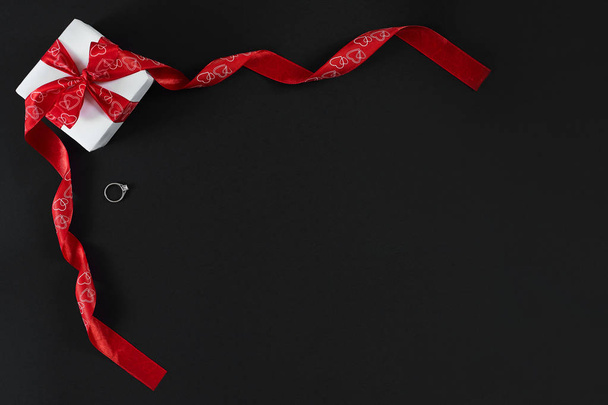 Bílá Dárková krabice s červenou stužkou a ring izolované na černém pozadí - Fotografie, Obrázek