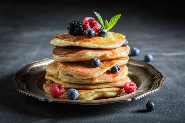 Closeup of american pancakes with maple syrup on dark table - Фото, зображення