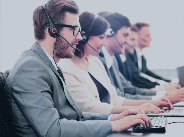 Attractive young man working in a call center with his colleagues - Zdjęcie, obraz