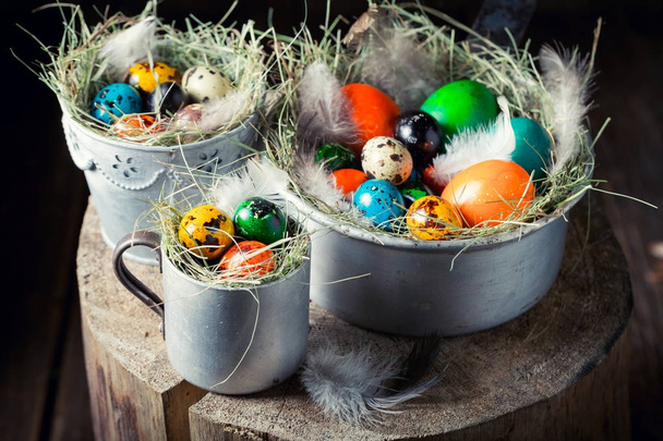 Closeup of eggs for Easter in nest and old mug - 写真・画像