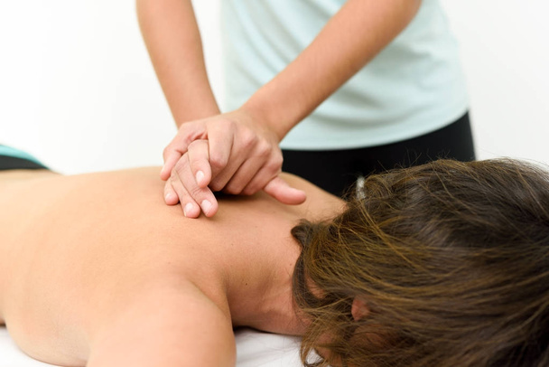 Young woman receiving a back massage in a spa center. - Φωτογραφία, εικόνα