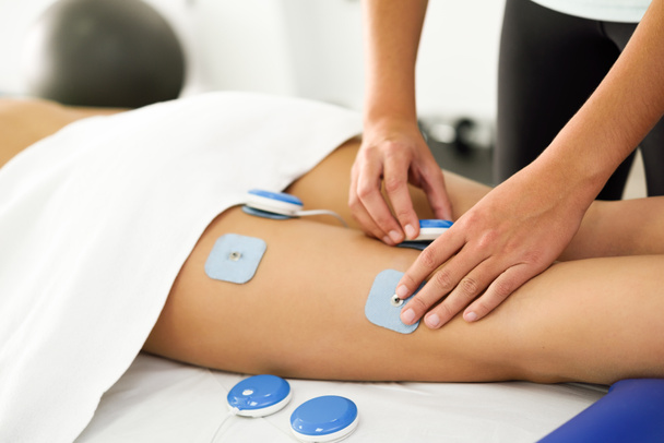 Fisioterapeuta aplicando eletroestimulação em fisioterapia
 - Foto, Imagem