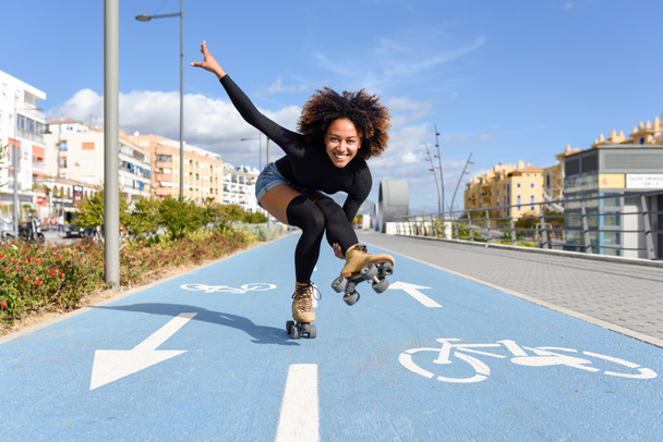 Schwarze Frau auf Rollschuhen fährt auf Radleine - Foto, Bild