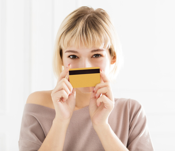 Усміхнена молода жінка показує кредитну картку
 - Фото, зображення