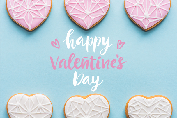 flat lay with arranged glazed heart shaped cookies isolated on blue, st valentines day holiday concept - Foto, immagini