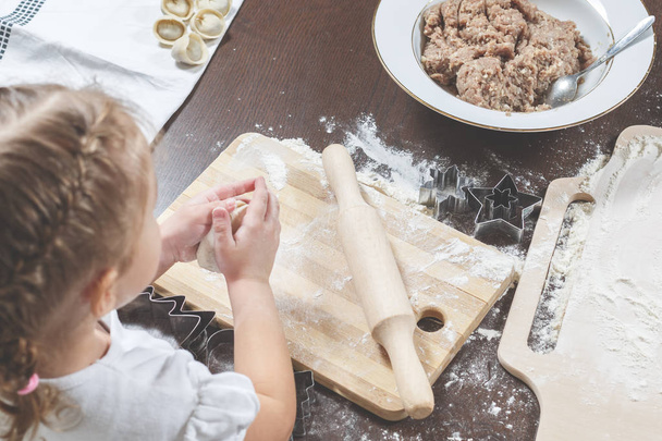 Little girl is making dumplings from dough - Foto, Imagem