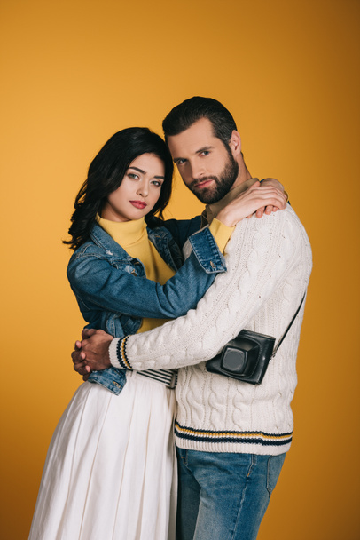 boyfriend and girlfriend hugging and looking at camera isolated on yellow - Fotó, kép