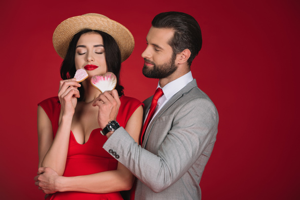 girlfriend sniffing cookies isolated on red - Foto, immagini