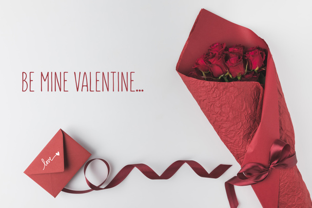 flat lay with bouquet of roses, ribbon and envelope isolated on white, st valentines day holiday concept - Photo, Image
