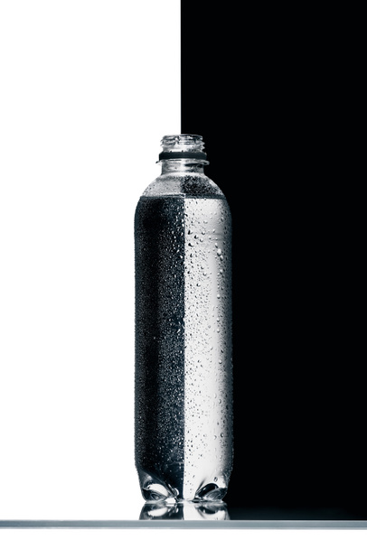 műanyag üveg víz, fél fekete-fehér háttér - Fotó, kép
