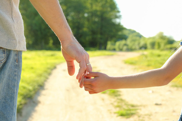 Eltern halten die Hand eines kleinen Kindes - Foto, Bild