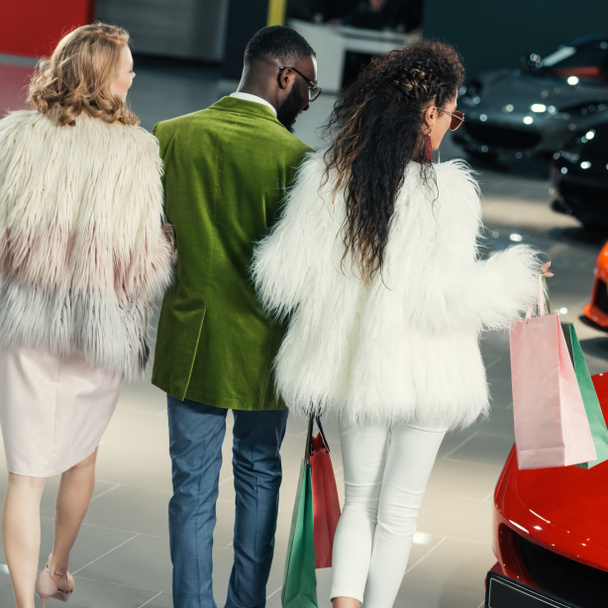 stylish young shoppers walking by auto showroom - Photo, Image