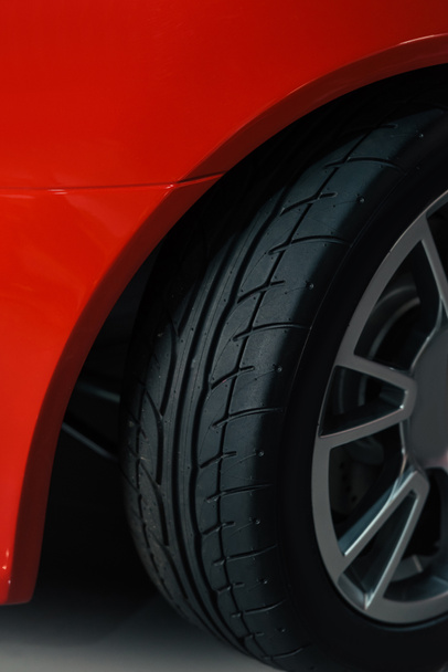 abgeschnittenes Rad eines roten Sportwagens - Foto, Bild