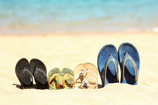 Pantoufles familiales sur le sable sur la plage
 - Photo, image