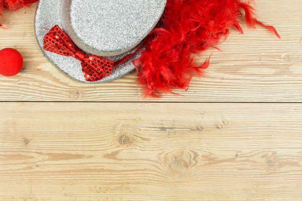 ezüst magas kalap, piros bolyhos toll boa, piros csokornyakkendő és vörös Anett - Fotó, kép