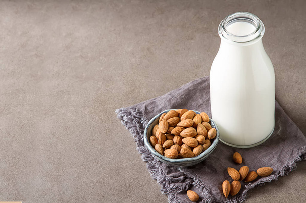 Dairy alternative milk. Almond milk in a glass bottle and fresh  - Φωτογραφία, εικόνα
