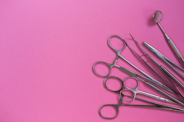 on the pink surface are medical dental instruments - Fotoğraf, Görsel