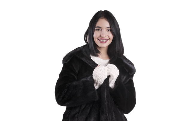 όμορφη κοπέλα σε ένα πορτρέτο απομονωμένες μαύρη γούνα παλτό, λευκό πουλόβερ γάντια - Φωτογραφία, εικόνα