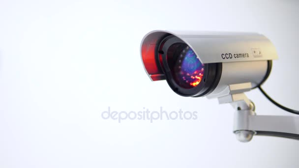 De bewakingscamera met knipperend rood licht op witte achtergrond. Close-up - Video