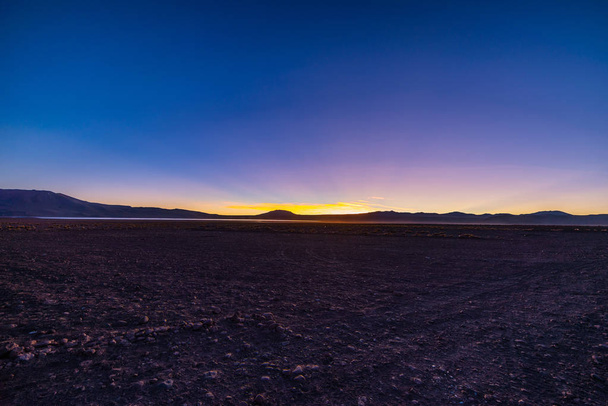 Altopiani sterili ad alta quota delle Ande, tra le più importanti destinazioni di viaggio in Bolivia. Erba incandescente al tramonto in primo piano con maestosa gamma di vulcani sullo sfondo
. - Foto, immagini
