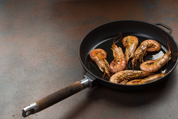 Giant prawns on hot pan stir fried in butter. Large tiger shrimps or langostinos in a frying pan - Valokuva, kuva