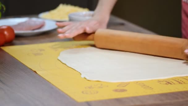 Ciasto na pizzę i wałek na drewnianym stole - Materiał filmowy, wideo