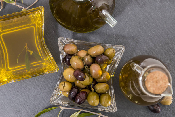 Green and black olives with olive oil bottles - Photo, image