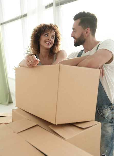 Happy couple standing near boxes in their new apartment. - Foto, Imagem