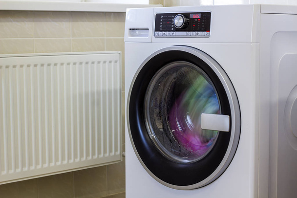 Ropa colorida y toallas en la lavadora
 - Foto, imagen