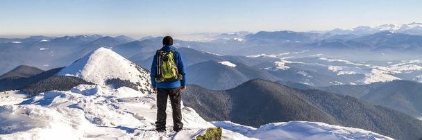 Man hiker on top of a mountain in winter - Photo, Image