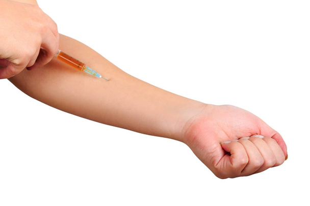 Közeli kép a kéz, oltási beteg egy fecskendő segítségével barna kábítószer. Steril injekció a felső kar. - Fotó, kép