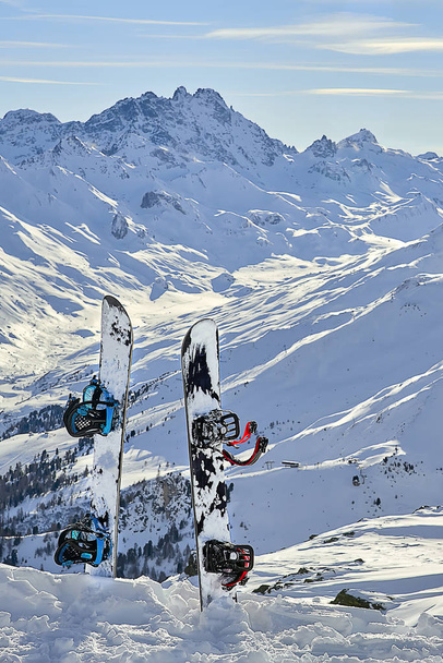 Two snowboard standing upright in snow between mountains on the background - Photo, Image