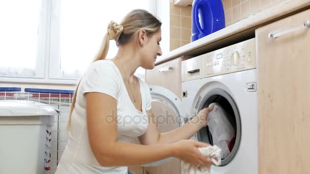 4 k video van jonge vrouw maakte de fout door het samenstellen van verschillende kleur kleding in de wasmachine - Video