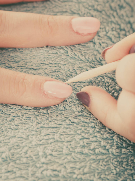 Kosmetikerin präpariert Nägel vor Maniküre, schiebt Nagelhaut zurück - Foto, Bild