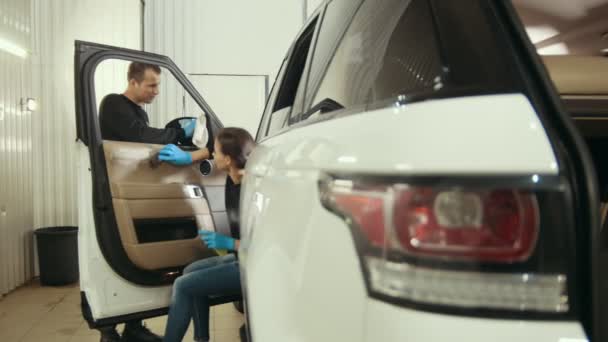 Молода дівчина і чоловік в рукавичках миють інтер'єр і двері автомобіля
 - Кадри, відео